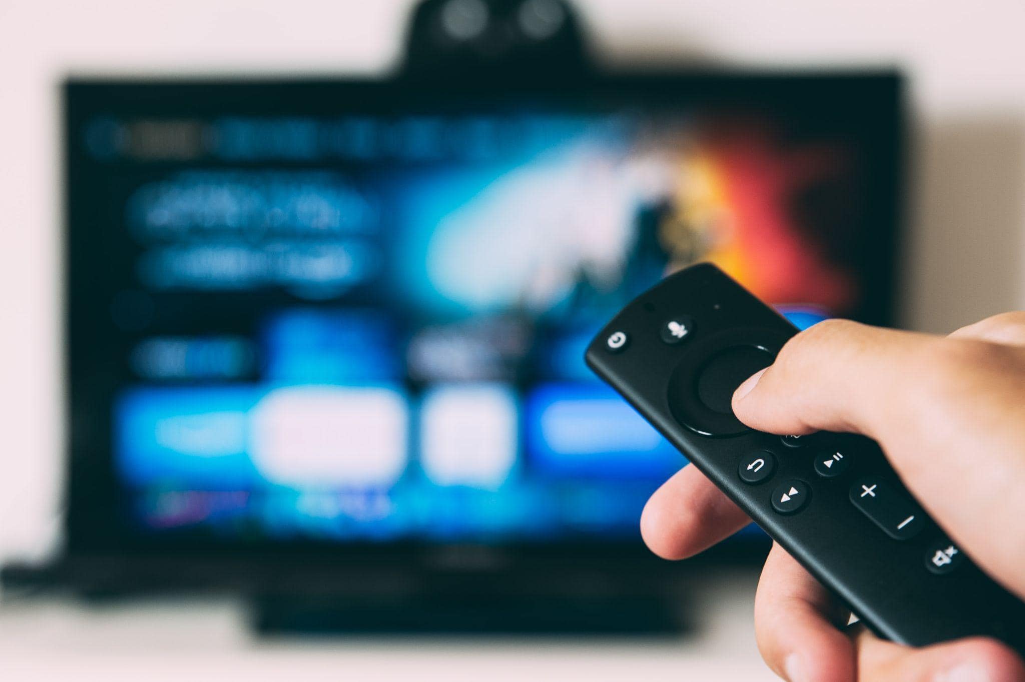 A remote control pointing at a TV screen